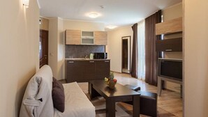 A compact living space with a kitchenette, a sofa, a coffee table, and a TV. - Complex Villa Brigantina (Nessebar)