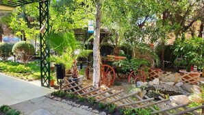 A garden with a stone pathway, wooden fence, and various plants. - Complex Villa Brigantina (Nessebar)