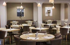 A restaurant with round tables and brown chairs, each set with cutlery and glassware. - Hotel Delphi Beach - All Inclusive (Dorida)