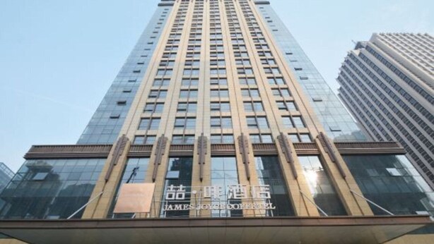 A tall building with a modern glass facade and a sign that reads "James Joyce Hotel". - James Joyce Coffetel (Zhengzhou)