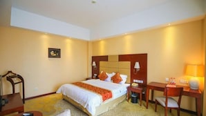 A hotel room with a large bed, bedside tables, a desk, and a chair. - Tianxinliang Hotel (Beijing)