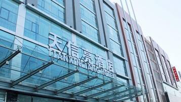 Un hotel moderno con fachada de vidrio y señalización que indica que es el XINLING HOTEL.