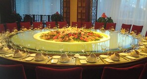 A round table set for a meal with chairs around it. - Tianxinliang Hotel (Beijing)
