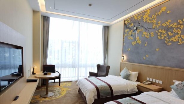 A hotel room with two beds, a desk, a TV, and a large window with curtains. - Tianxinliang Hotel (Beijing)