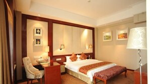 A hotel room with a large bed, a desk, a chair, and a bench. - Tianxinliang Hotel (Beijing)