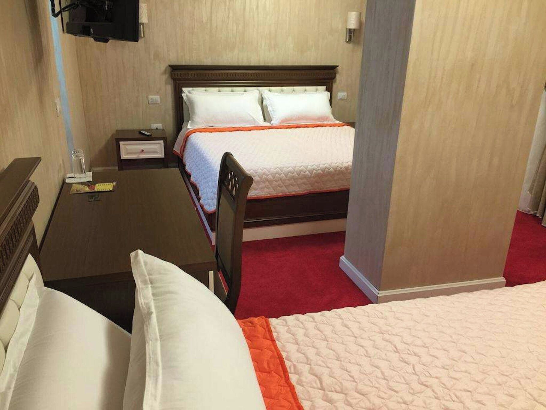 A hotel room with a bed, a desk, and a chair.
