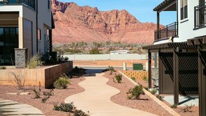 A modern residential area with two houses, a paved walkway, and a mountain in the background. - Ocotillo Springs #20 Beautiful Unit Close to Trails/Hiking (Santa Clara)