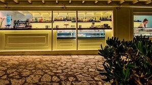 Un bar con piso de baldosas y barra con diferentes botellas.