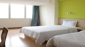 A hotel room with two beds, a window with curtains, and a chair. - 7 Days Inn Jinhuabei Road (Xi'an)