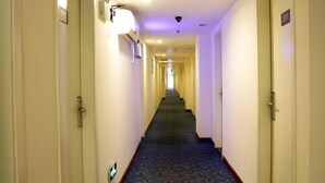 A hotel hallway with doors numbered 301 and 302, a carpeted floor, and a light fixture on the wall. - 7 Days Inn Jinhuabei Road (Xi'an)