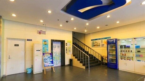 A lobby with a staircase, a vending machine, and a bulletin board. - 7 Days Inn Jinhuabei Road (Xi'an)