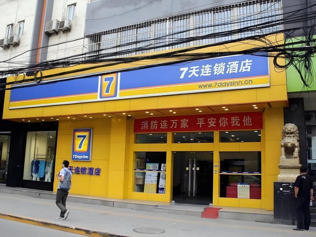 A hotel with a prominent '7' sign, a website address, and a red sign with Chinese characters.