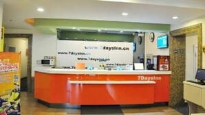 A reception desk with a sign displaying the website www.7daysinn.cn. - 7 Days Inn Harbin Railway Station Qiulin Shop (Harbin)