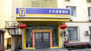 A hotel entrance with a prominent number 7 sign, a website address, and traditional red decorations. - 7 Days Inn Harbin Railway Station Qiulin Shop (Harbin)