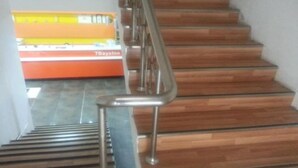 Una escala amb graons de fusta i barana metàl·lica.