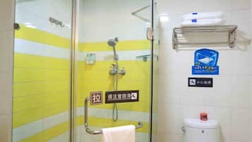 A bathroom with a glass shower enclosure, a towel rack, a toilet, and a shelf with toiletries.