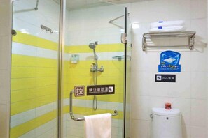 A bathroom with a glass shower enclosure, a towel rack, a toilet, and a shelf with toiletries. - 7 Days Premium (Harbin)