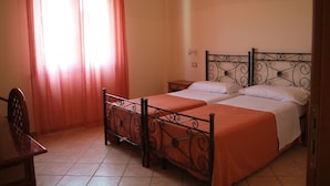A bedroom with two beds, a desk, and a chair. - Agriturismo Ninea (Ricadi)