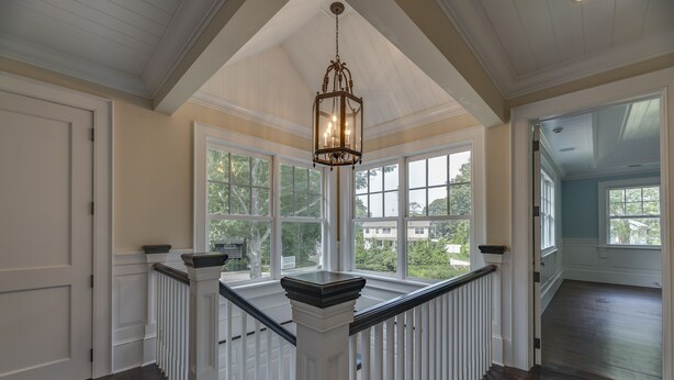 A spacious room with a high ceiling, large windows, and a wooden railing. - Mansion Near the Bay. 7 bedrooms! Chef’s kitchen. (Southampton)