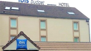 Een gebouw met een bord waarop “ibis budget HOTEL” staat en een kleiner bord eronder met “ibis budget MOTELS.”