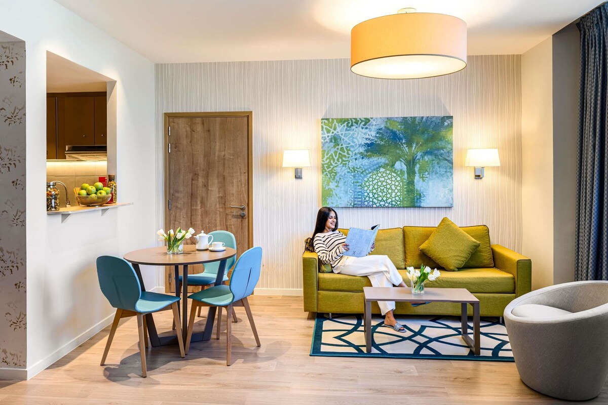 Una sala de estar moderna con un sofá, una mesa de centro y un comedor con sillas.