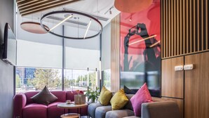 Een modern interieur met een bank, een bijzettafeltje en een groot raam met uitzicht op de stad.