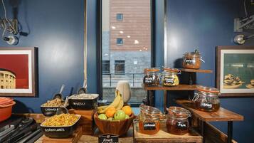 A breakfast bar with various food items, including granola, mixed fruit, and honey.