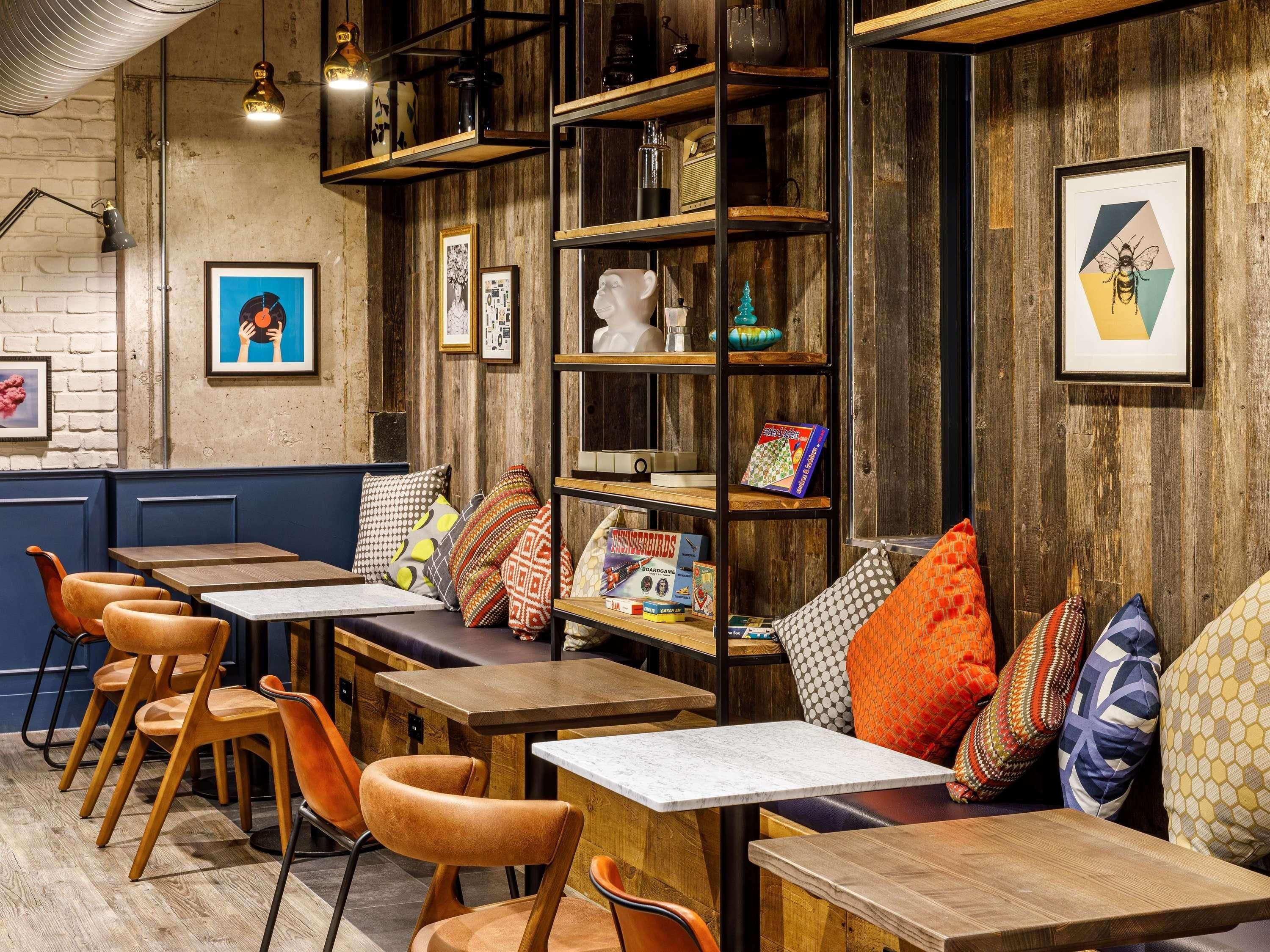 A restaurant interior with wooden walls, metal shelves, and various framed pictures.