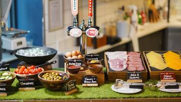 A food display with various items like boiled eggs, ham, cheese, and tomatoes.