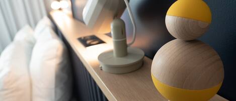 A bedside table with a lamp and a wooden decorative object.