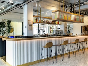 A modern bar area with a counter, stools, and a variety of bottles. - ibis Styles Paris Romainville (Romainville)
