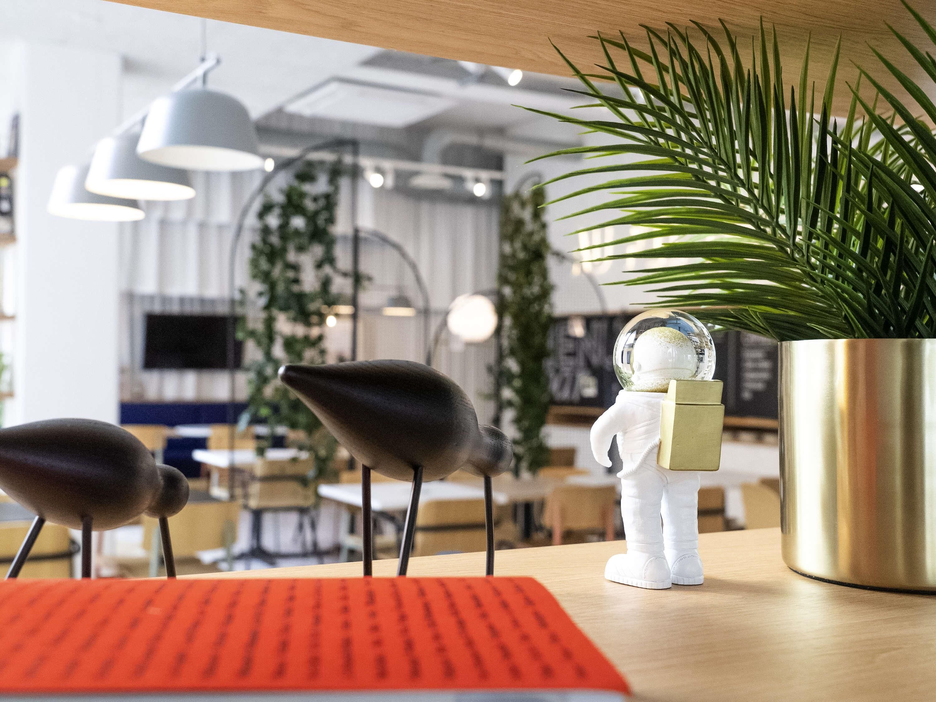A modern office space with a desk, a potted plant, and a decorative item resembling a snow globe.