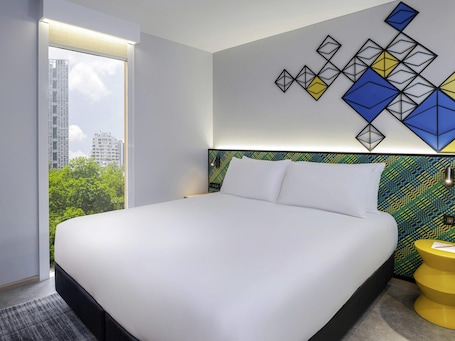In-room safe, desk, laptop workspace, blackout drapes. ibis Styles Bangkok Silom