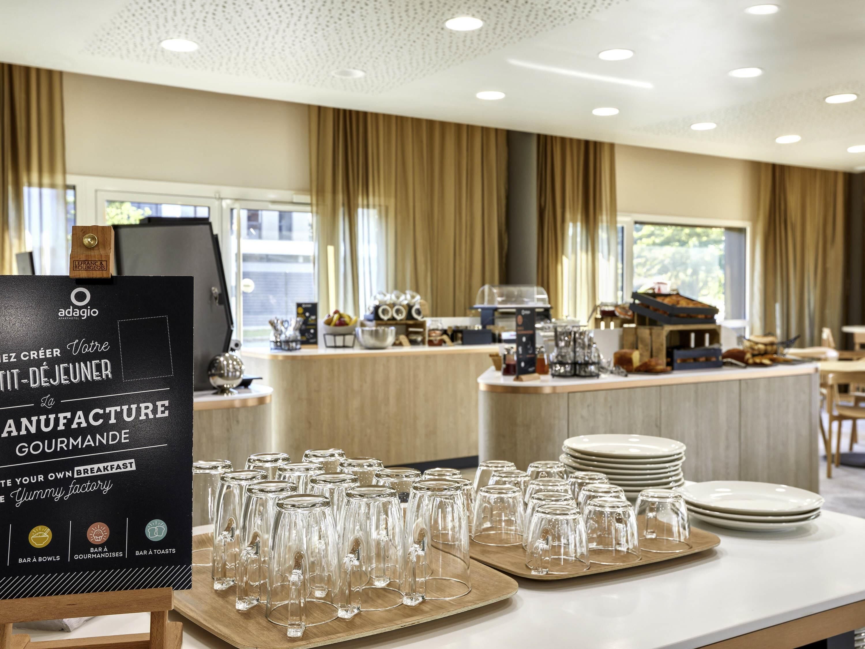 A breakfast setup with a menu board, glassware, plates, and a coffee machine in a hotel room.