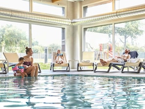 Una piscina techada, sillones reclinables de piscina