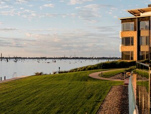 Un bâtiment moderne offrant une vue sur un lac paisible et une zone verdoyante.