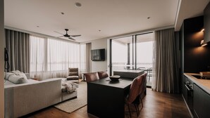 Una sala moderna con sofá, una mesa de comedor y una zona de cocina.