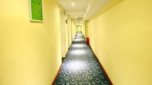 Un pasillo estrecho con paredes amarillas y piso estampado.