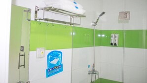 A bathroom with green and white tiles, a glass shower enclosure, a towel rack, and a soap dispenser. - 7 Days Inn Railway Station San Xiang Market Branch (Changsha)