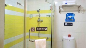 A bathroom with a glass shower enclosure, a towel rack, a toilet, and a shelf with toiletries. - 7 Days Inn Railway Station San Xiang Market Branch (Changsha)