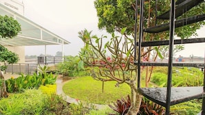 A garden with a variety of plants and a metal structure. - Collection O Sweet Karina (Bandung)