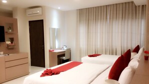 A hotel room with two beds, a desk, a chair, and a TV. - Collection O Sweet Karina (Bandung)
