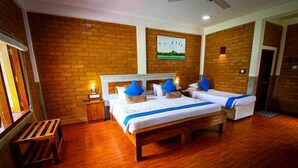 Quarto com duas camas, piso de madeira, paredes de tijolo e um quadro na parede.