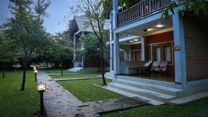 Um edifício com varanda coberta, degraus que levam à entrada e uma placa com o número 124.