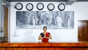 A reception desk with a large elephant mural and five clocks above it. - Elephas Resort & Spa (Avudangawa)