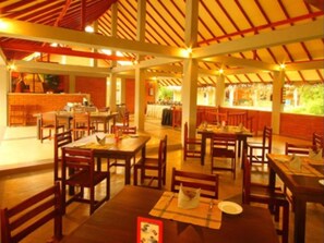 Enjoy meals in a spacious dining area with tables arranged for easy movement, surrounded by a brick-patterned wall and a service counter.