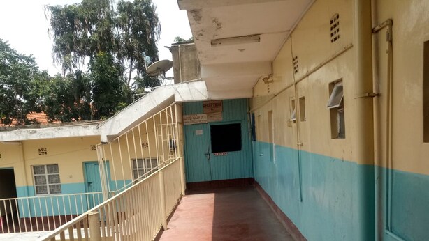 A corridor with a metal railing, a reception area, and a door labeled "RECEPTION". - Heshima Lodge (Naivasha)