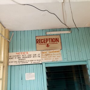 A reception area with a sign indicating 'RECEPTION' and a notice about valuables. - Heshima Lodge (Naivasha)