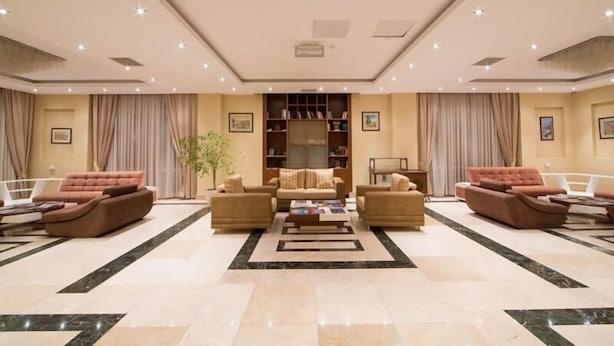 A spacious lobby with a central coffee table, sofas, and a bookshelf. - Gabala City Hotel (Gabala)