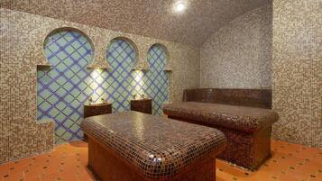 Unique mosaic tile design adorns the walls and floor, complemented by arched windows and a sloped ceiling.